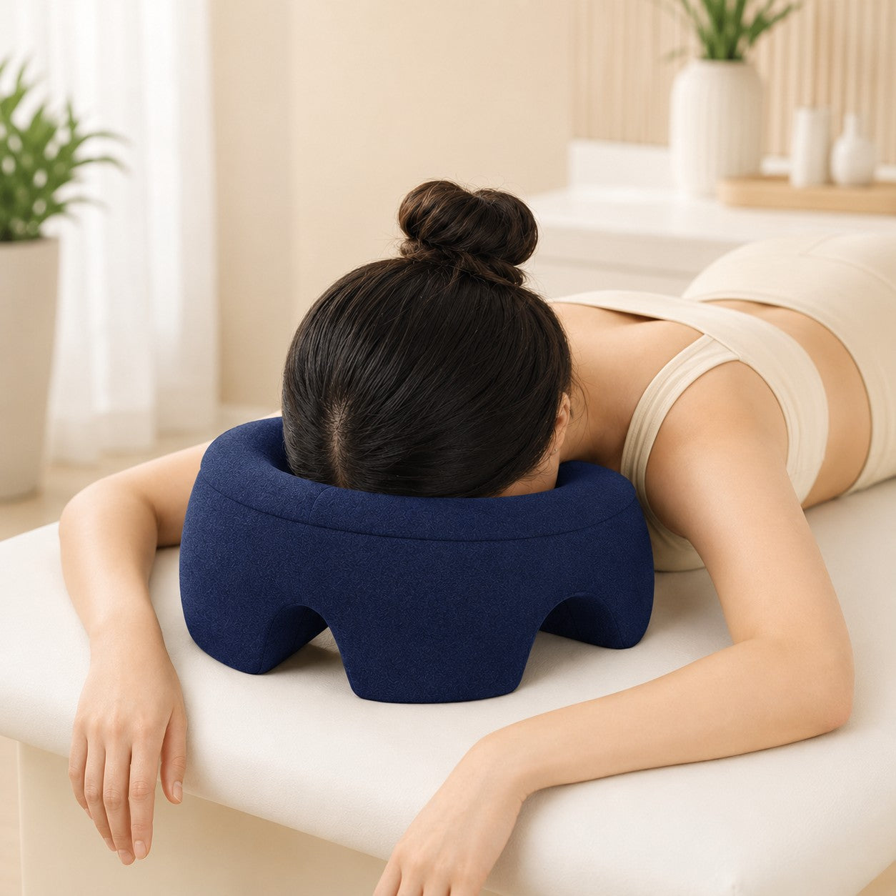 Woman resting face down on the navy FaceRest pillow