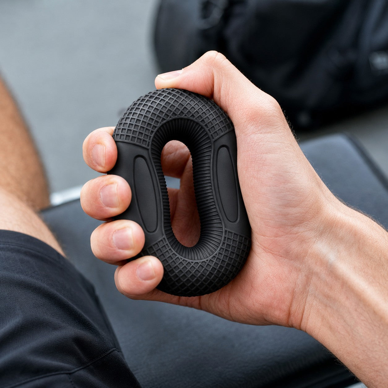 Close-up squeezing the black GoodGrip silicone grip strengthener