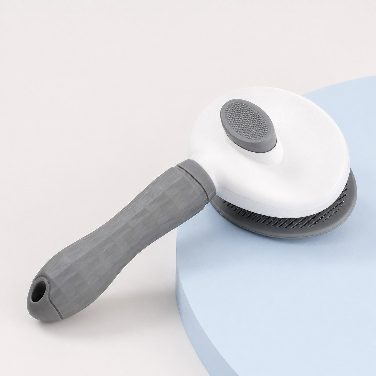 Close-up of the PurrGroom brush head and easy-grip handle