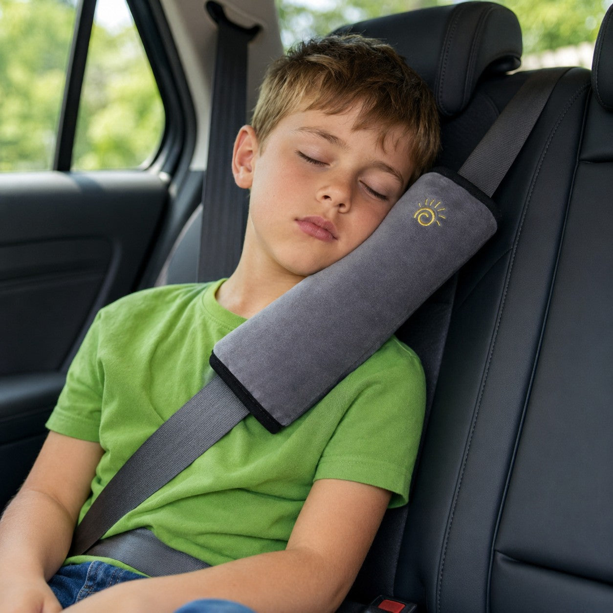 Child resting comfortably against the grey SnugBelt seat-belt pillow in the car