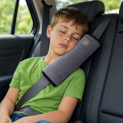 Child resting comfortably against the grey SnugBelt seat-belt pillow in the car